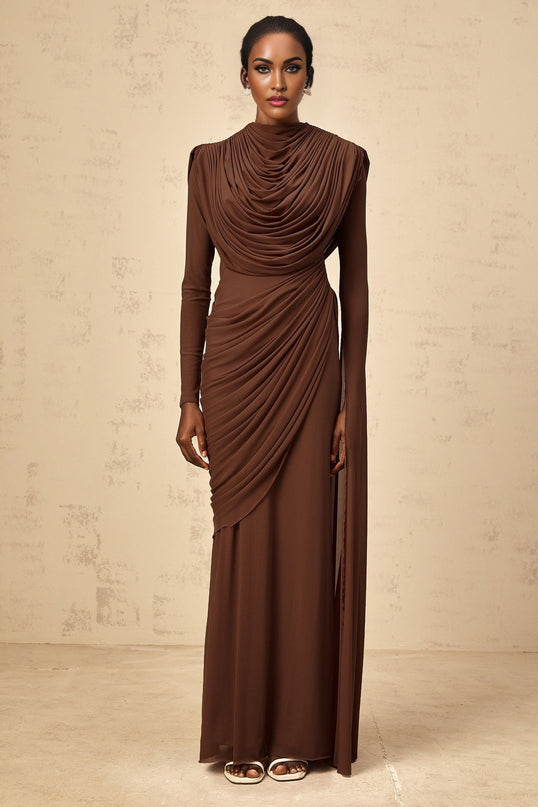 A long brown maxi dress with shirred detailing and draped fabric flowing from top to bottom