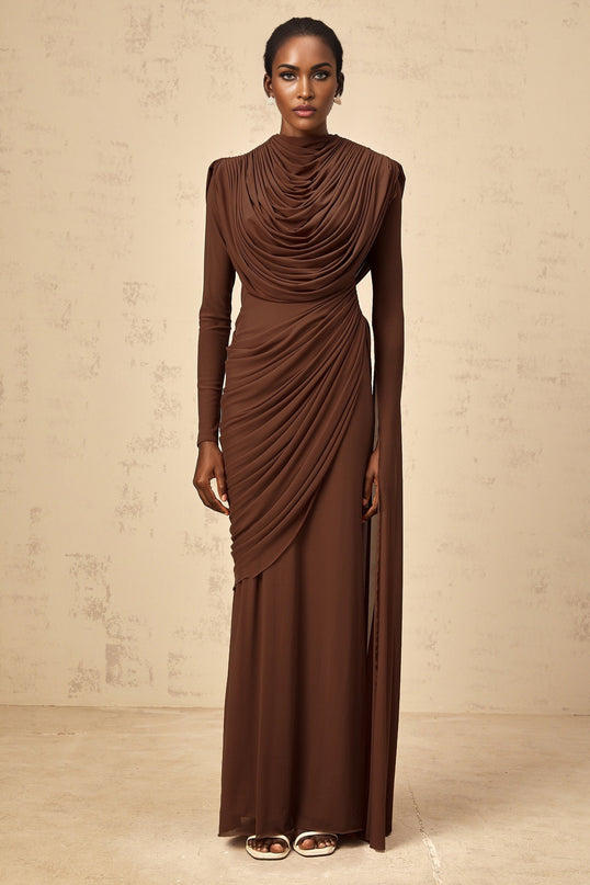 A long brown maxi dress with shirred detailing and draped fabric flowing from top to bottom