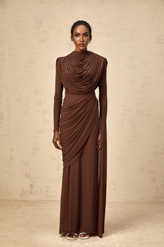 A long brown maxi dress with shirred detailing and draped fabric flowing to the floor