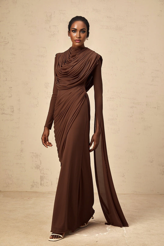 A long brown maxi dress with shirred details and draped fabric featuring a flowy silhouette and elegant design