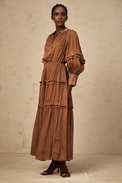 A long brown maxi dress with tiered layers and ruffled trim details