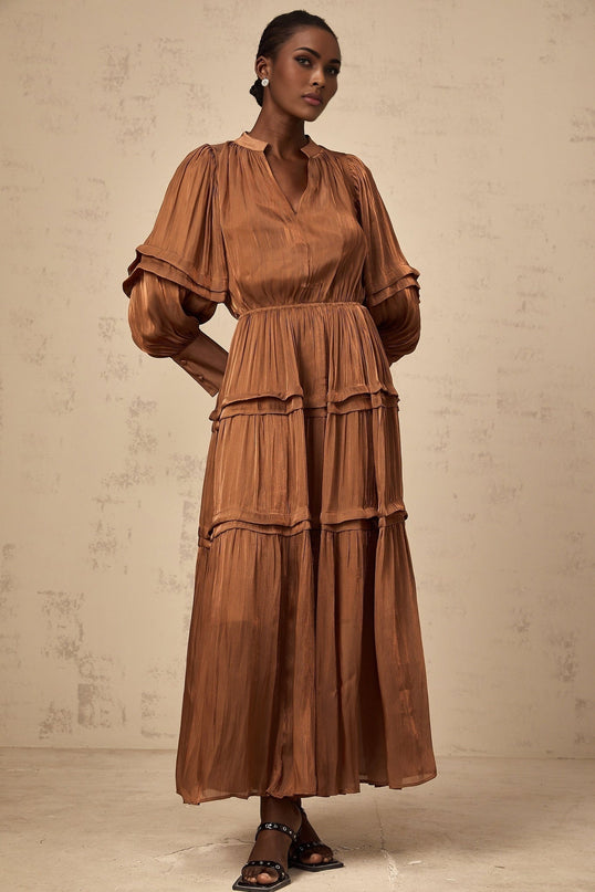A long brown maxi dress with tiered layers and ruffled trim details