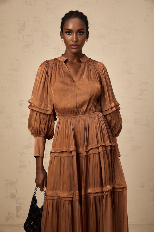 A long brown maxi dress with tiered layers and ruffled trim details