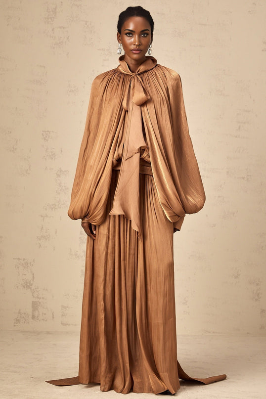 A long brown pleated satin maxi dress with a flowing silhouette and elegant design