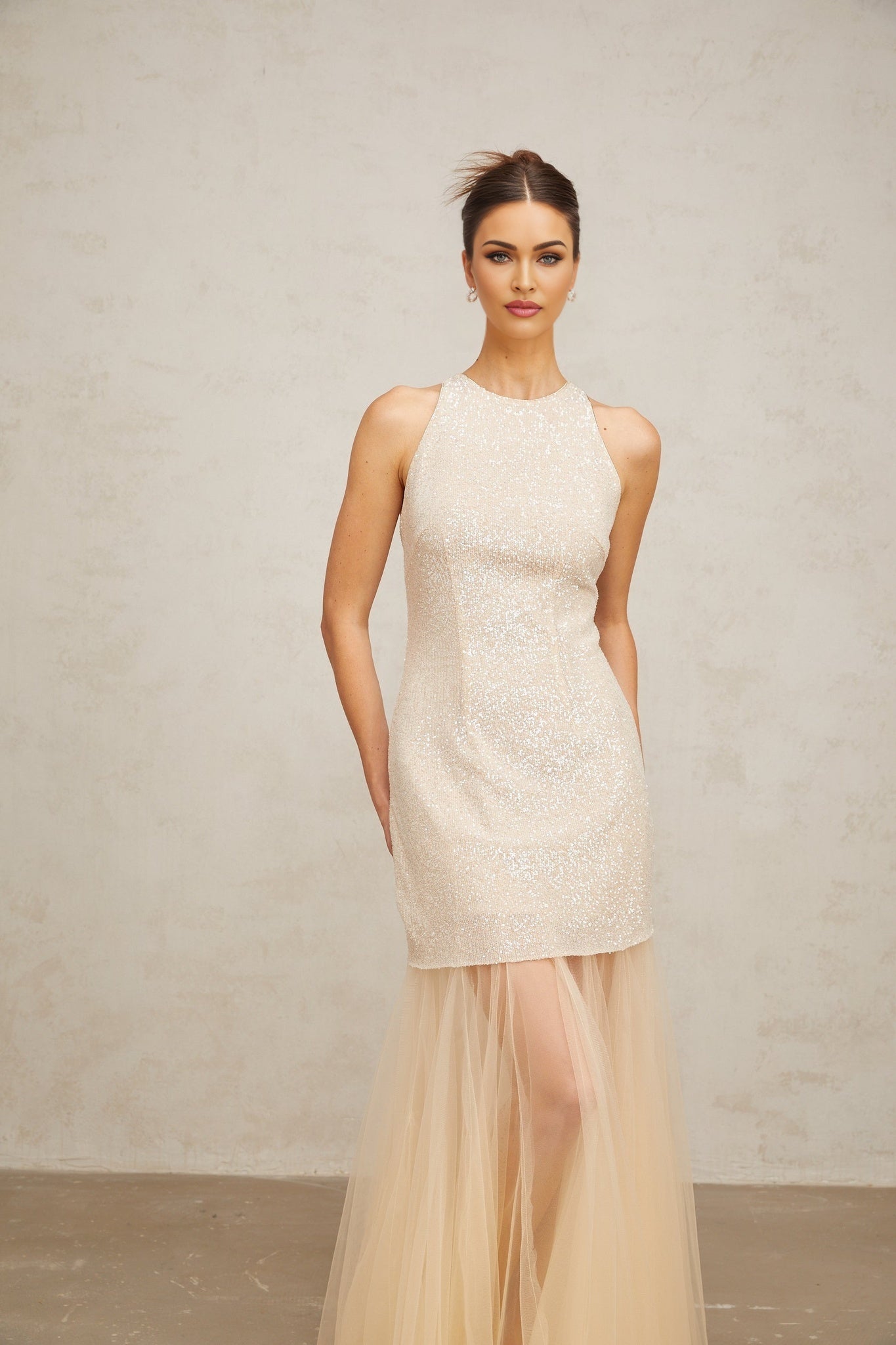 A long champagne colored maxi dress with sequins and sheer tulle panels