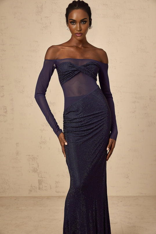 A long dark blue maxi dress with a corset bodice featuring embellishments and sheer tulle panels