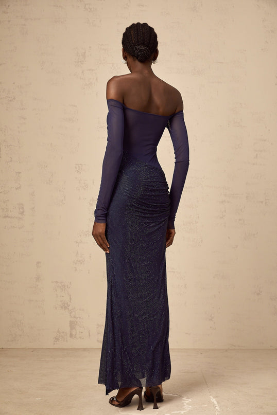 A long dark blue maxi dress with a corset bodice featuring tulle panels and embellished details
