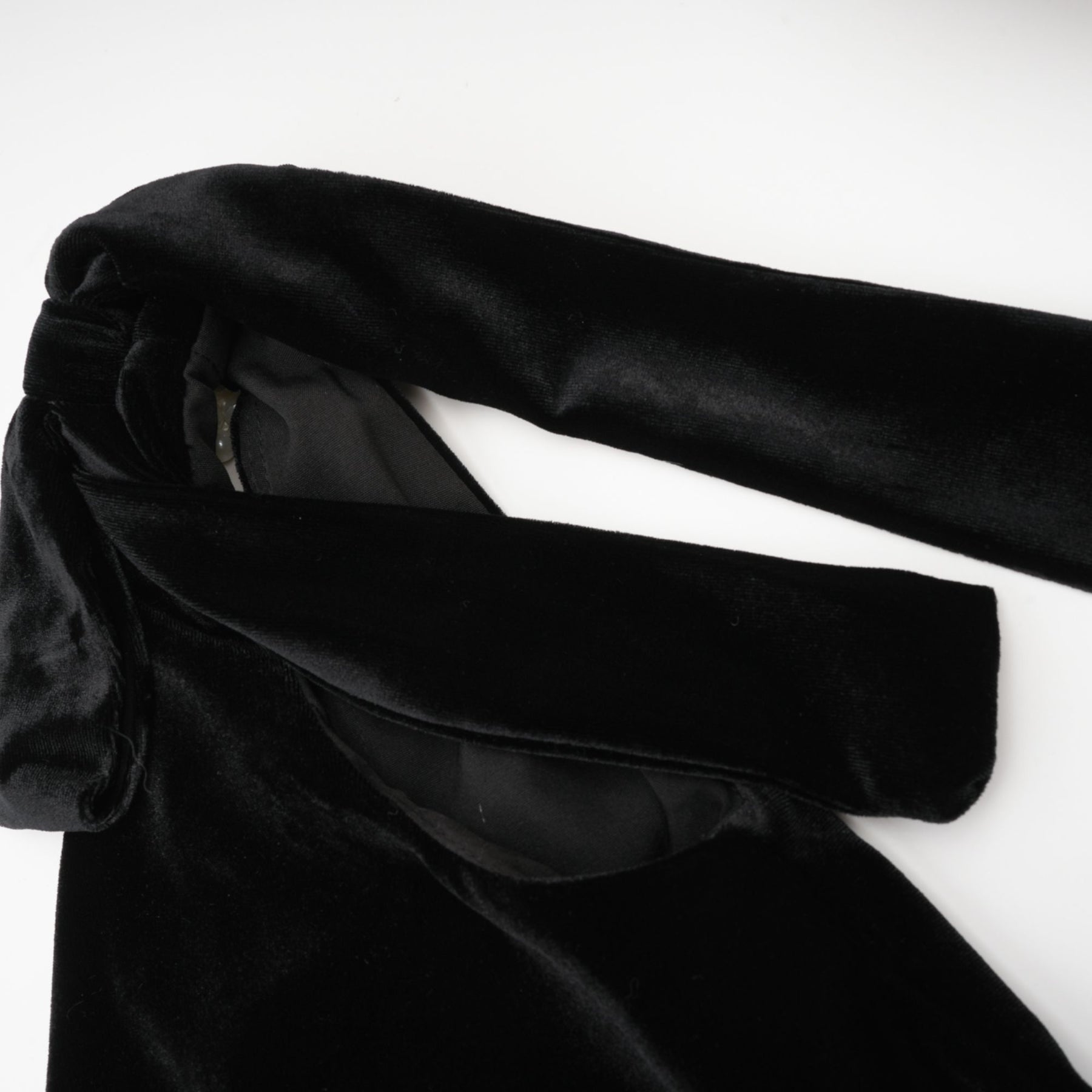 A long dark velvet dress with an open back and embellished details named Audrey shown on a model against a plain background