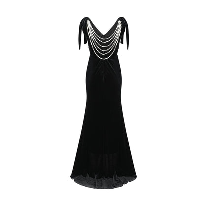 A long dark velvet dress with an open back and embellished details named Audrey shown on a model