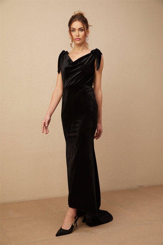 A long dark velvet maxi dress with embellishments and an open back styled on a mannequin or model