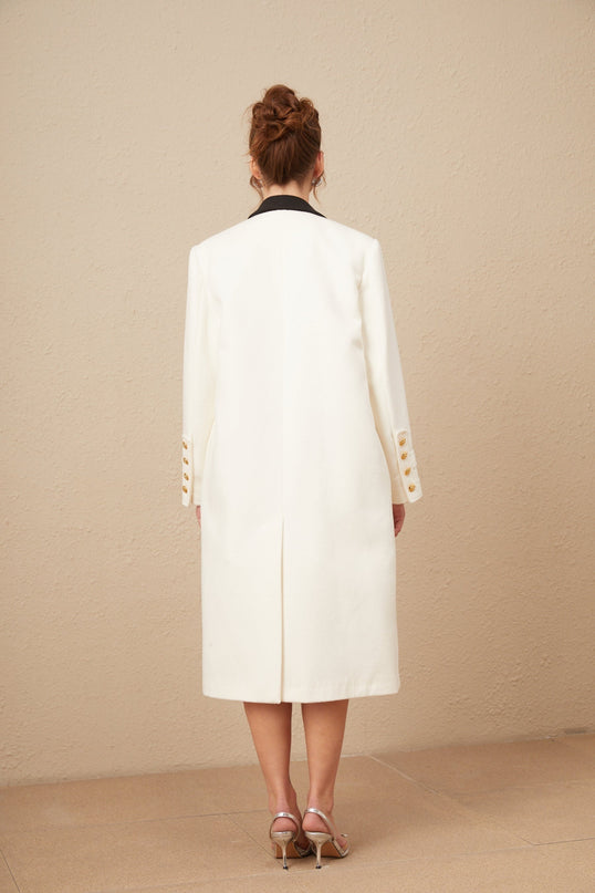 A long doublebreasted blazer featuring colorblocked panels in shades of wool with a terebinthine hue contrasting against other neutral tones