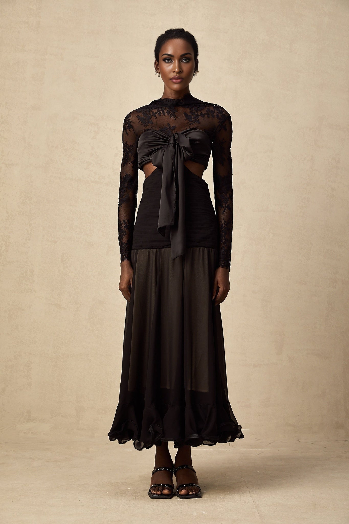 A long elegant maxi dress with floral lace panels featuring a delicate pattern throughout the garment The dress has a flowing silhouette and appears to be made of lightweight fabric suitable for formal or evening wear