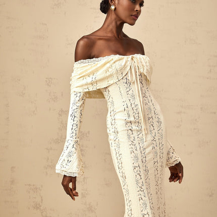 A long elegant neutral colored maxi dress with floral lace details and a train design