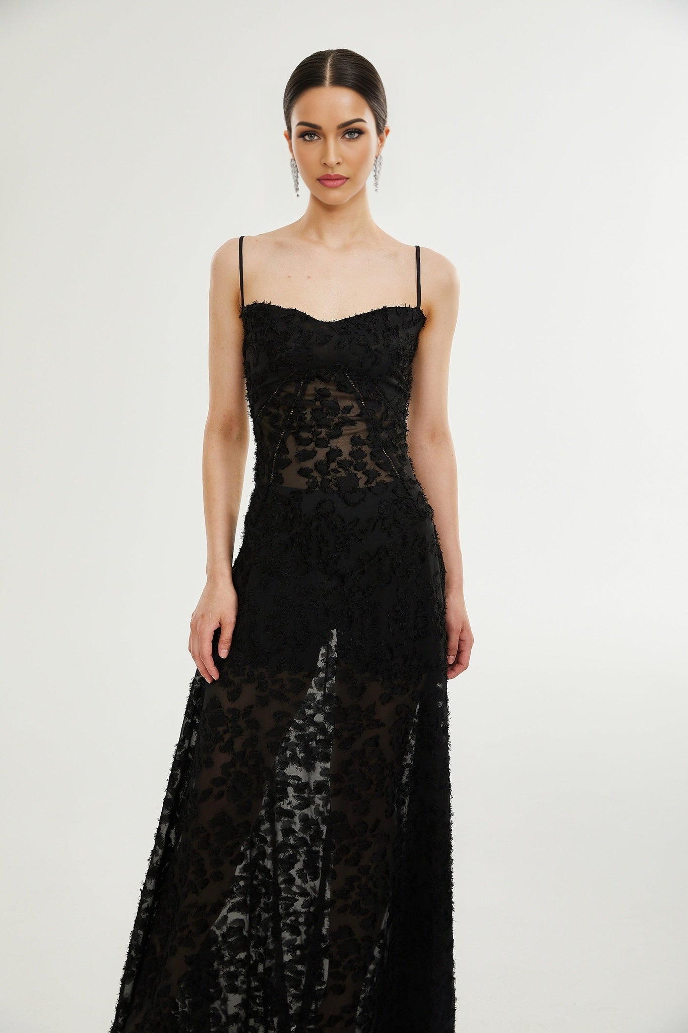 A long floral lace maxi dress with a feminine silhouette featuring delicate floral patterns and a floor length design