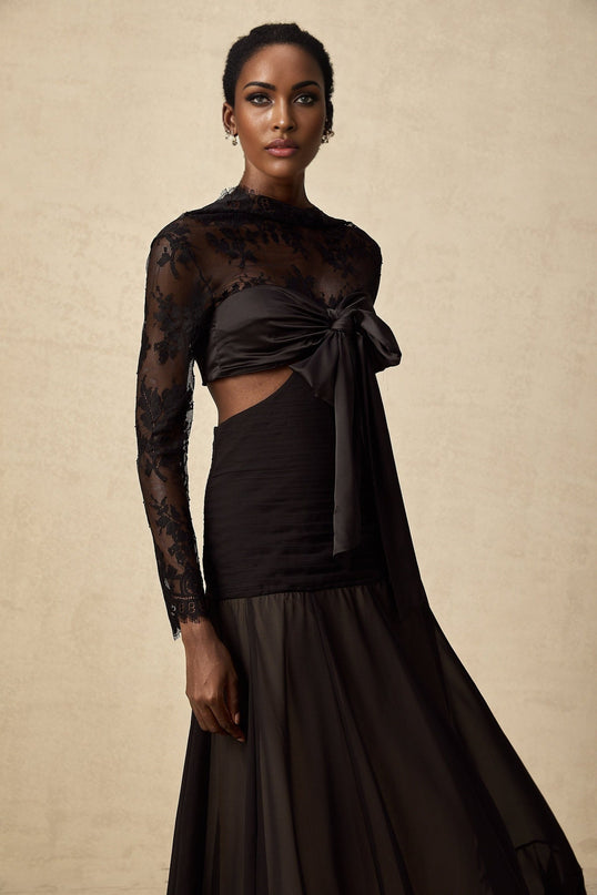 A long floral lace maxi dress with sheer panels featuring a delicate floral pattern throughout the bodice and skirt creating an elegant and romantic silhouette