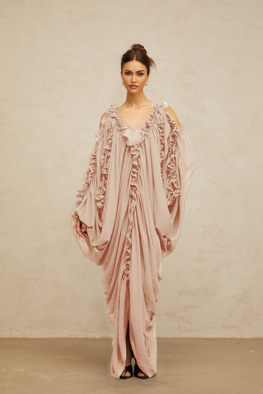 A long flowing maxi dress made of tulle fabric with ruffled trim details featuring a light and airy design