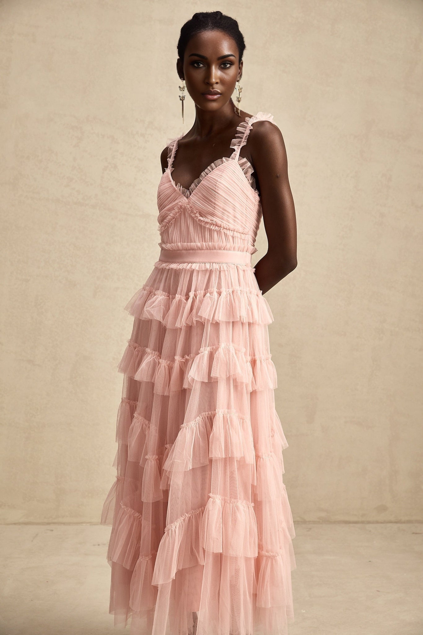 A long flowing maxi dress with layered ruffles made of tulle fabric featuring a romantic and ethereal design