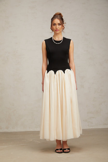 A long flowing maxi dress with puffed sleeves featuring colorblocked sections in contrasting hues named Josette