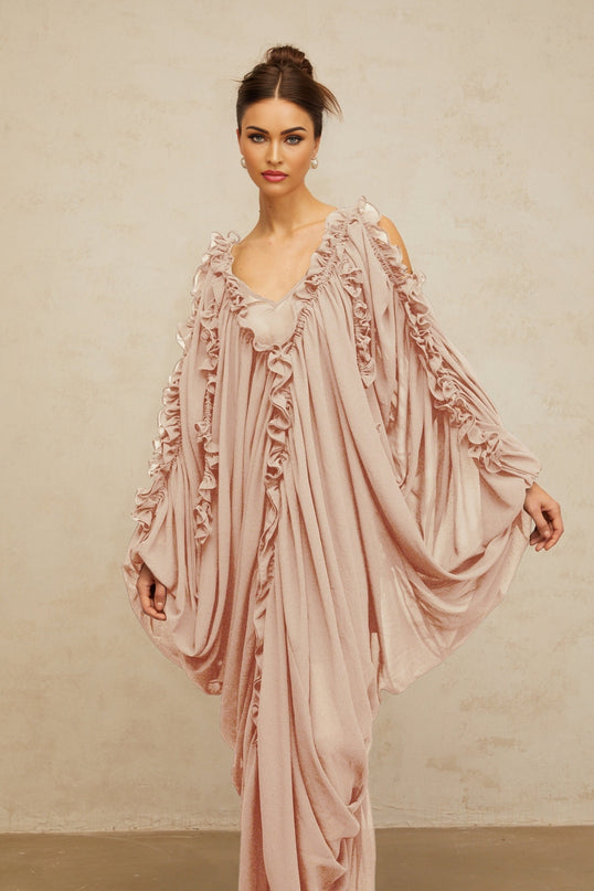 A long flowing white tulle maxi dress with delicate ruffled trim details and a romantic ethereal look