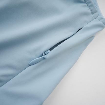 A long flowy baby blue maxi dress with an asymmetric neckline and pleated skirt detail