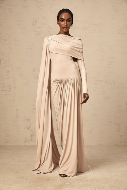 A long flowy maxi dress in neutral tones featuring a unique ribbon design and draped silhouette