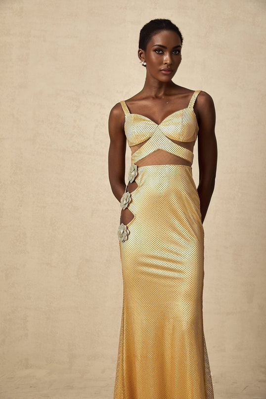 A long gold maxi dress with floral cutout patterns featuring a sleeveless design and flowing silhouette