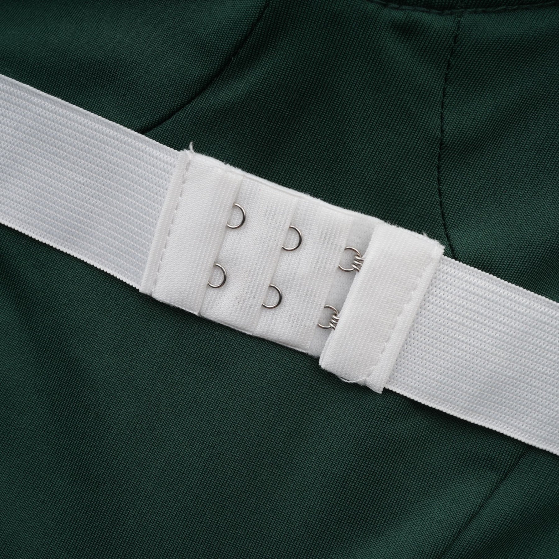 A long green maxi dress with a corset bodice featuring ribbon design details and a flowing skirt