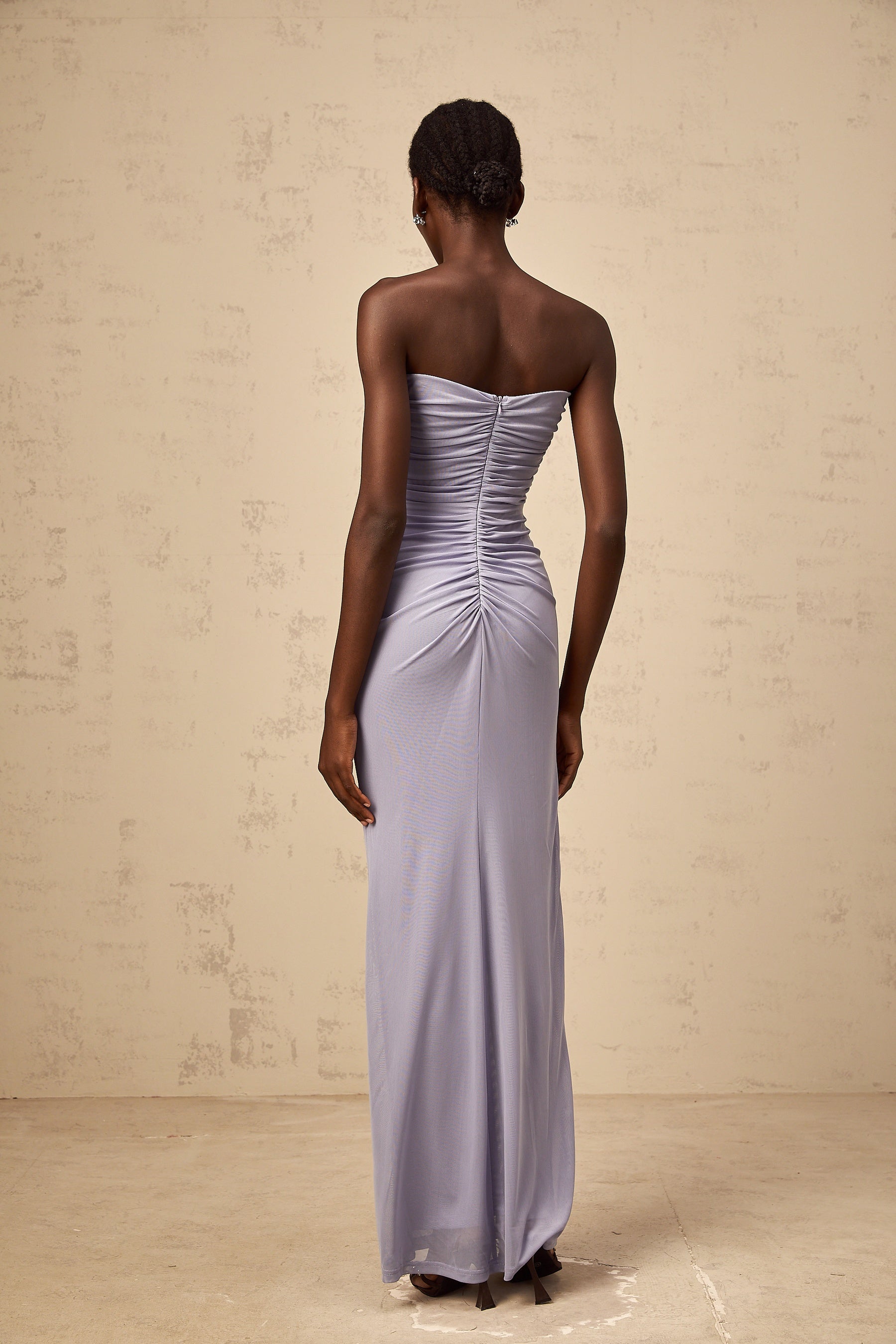 A long lavender maxi dress with a corsetstyle bodice featuring ruched 3D petal details and a flowing skirt