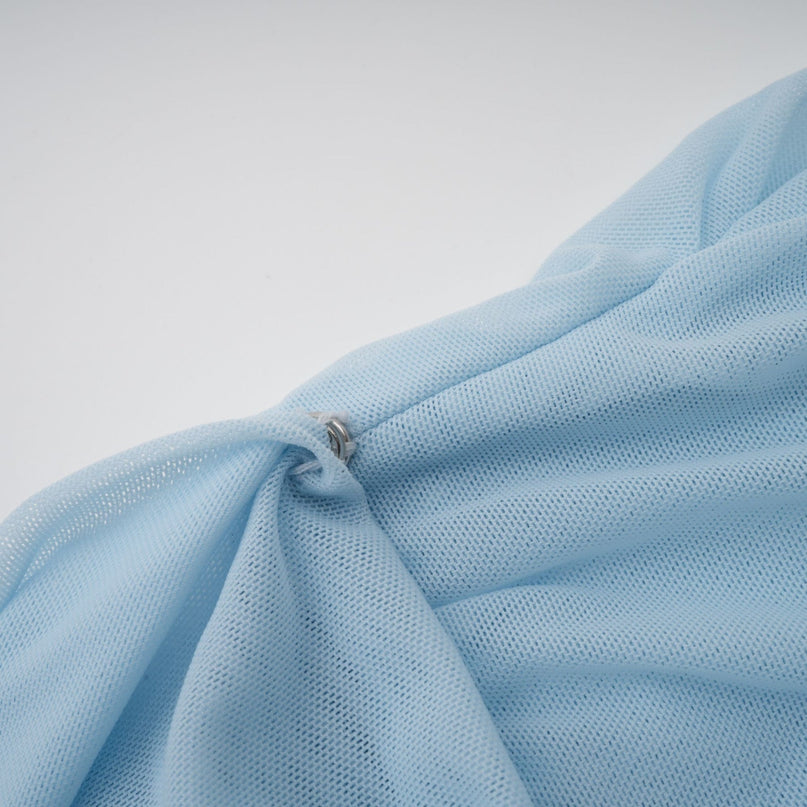 A long light blue asymmetric maxi dress with pleated details and a flowing silhouette