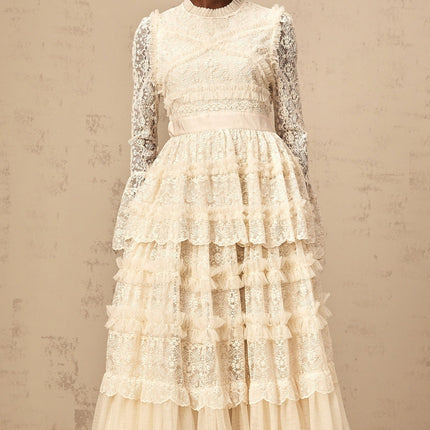 A long neutral colored maxi dress with lace panels and ruffled tulle details