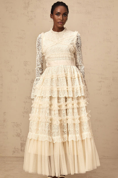 A long neutral colored maxi dress with lace panels and ruffled tulle details