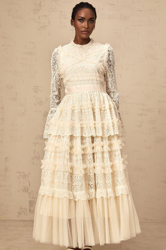 A long neutral colored maxi dress with lace panels and ruffled tulle details