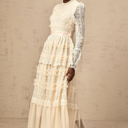 A long neutral colored maxi dress with lace panels and ruffled tulle details
