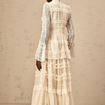 A long neutral colored tulle maxi dress with lace panels and ruffled details featuring a feminine silhouette and delicate design elements