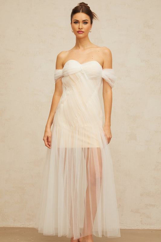 A long off white maxi dress with pleated tulle fabric featuring a flowy silhouette and delicate design details