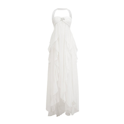 A long pink chiffon maxi dress with a halter neck and ruffled details worn by a model standing against a plain background