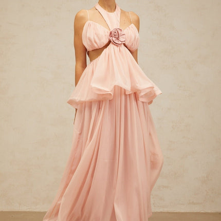 A long pink maxi dress with floral applique details and cut out sections featuring a feminine silhouette and delicate design