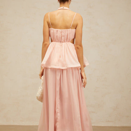 A long pink maxi dress with floral applique details and cutout sections featuring a flowy silhouette and romantic design