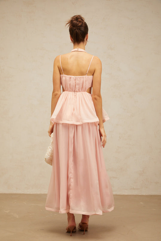 A long pink maxi dress with floral applique details and cutout sections featuring a flowy silhouette and romantic design