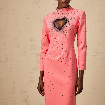 A long pink maxi dress with heart shaped cutouts and embellishments featuring a feminine silhouette and romantic design