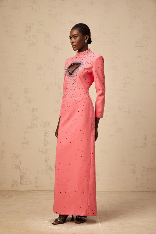 A long pink maxi dress with heart shaped cutouts and embellishments named Zelie