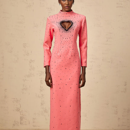 A long pink maxi dress with heart shaped cutouts and embellishments