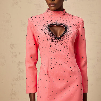 A long pink maxi dress with heart shaped cutouts and embellishments