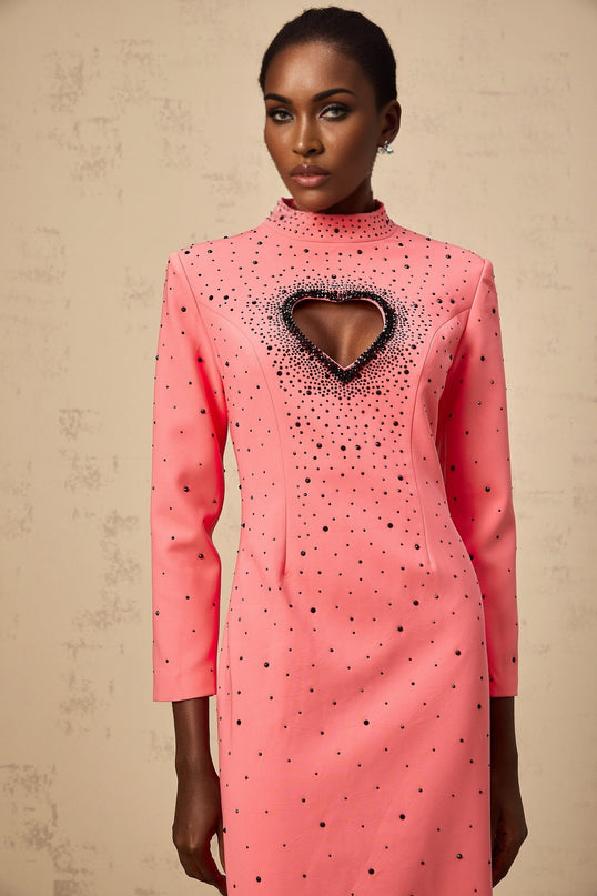A long pink maxi dress with heart shaped cutouts and embellishments