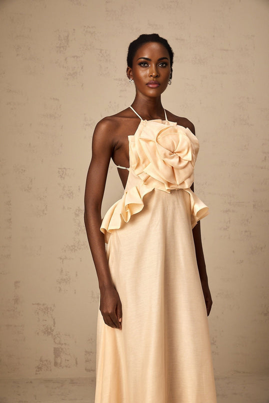 A long pink maxi dress with ruffled 3d petal details covering the entire garment creating a textured floral appearance