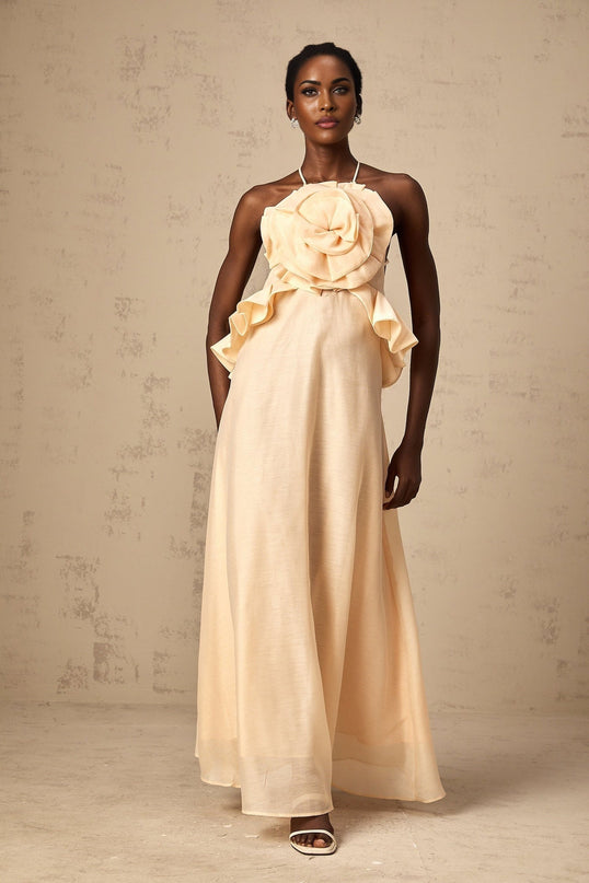 A long pink maxi dress with ruffled 3D petal details throughout creating a layered floral effect