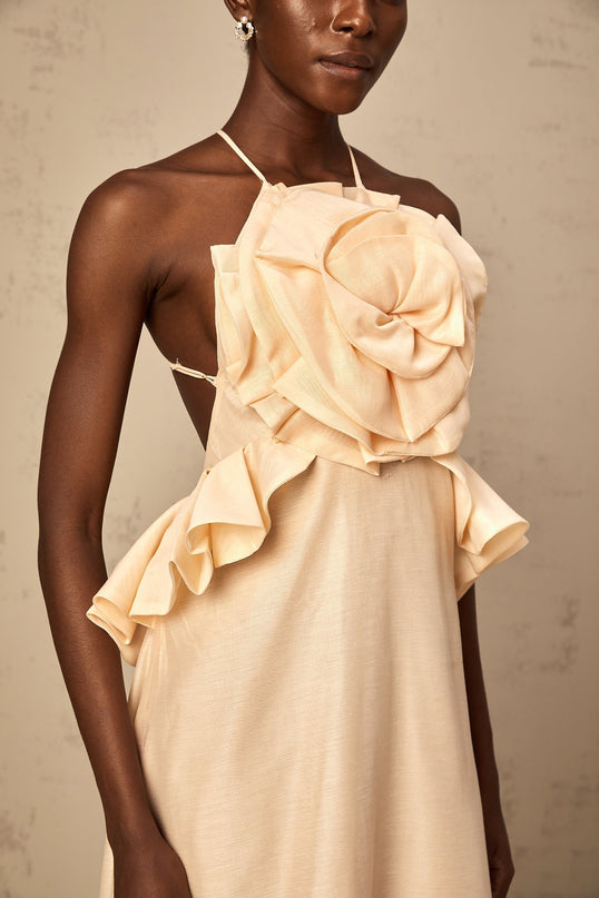 A long pink maxi dress with ruffled 3d petal details throughout creating a romantic and textured appearance