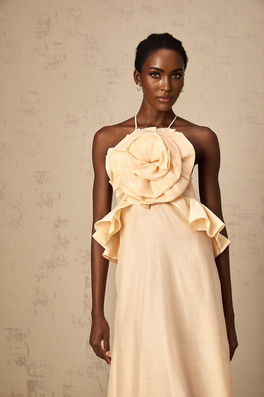 A long pink maxi dress with ruffled 3d petal details throughout creating a textured floral appearance