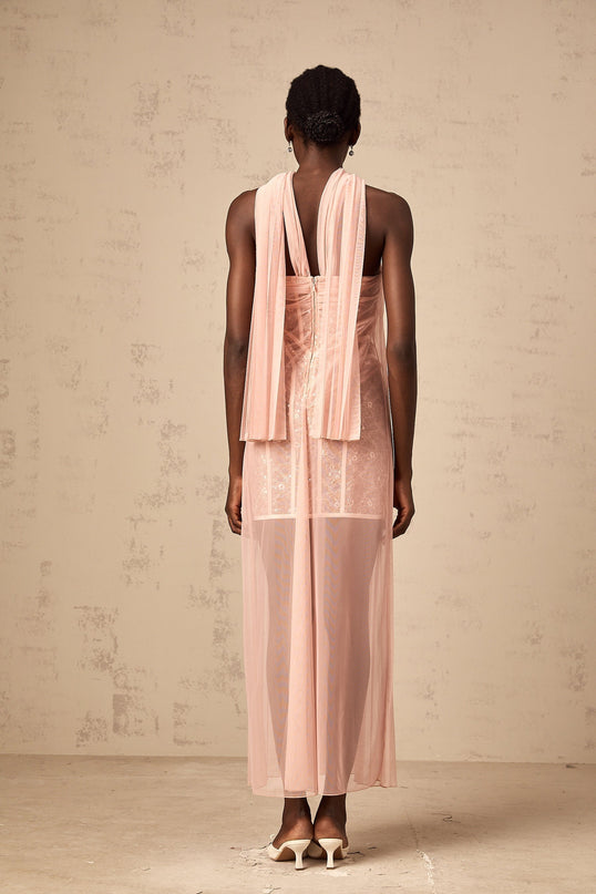 A long pink tulle maxi dress with pleats and ribbon design details modeled on a female figure