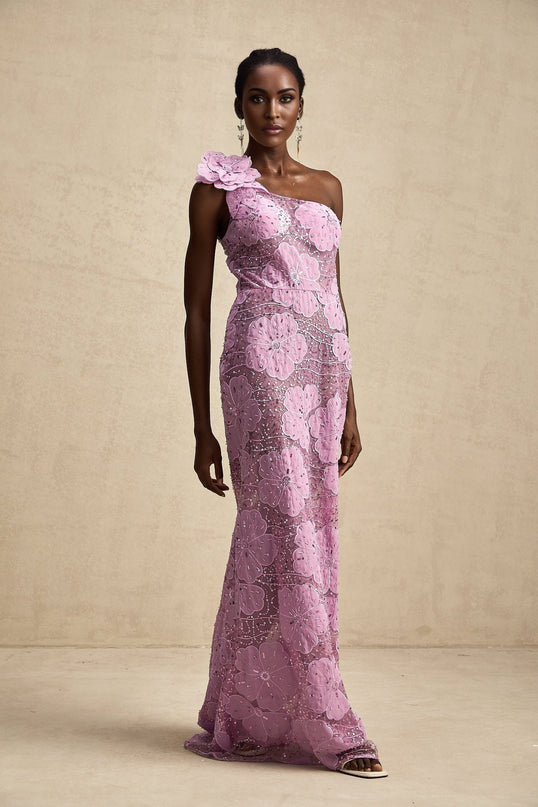 A long purple maxi dress with floral applique details adorning the fabric